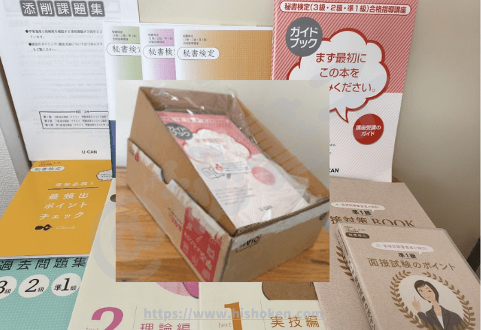 ユーキャン「秘書検定3級・2級・準1級合格指導講座」で送られてくるテキストなど一式が段ボールに入っている様子 ①ガイドブック ②テキスト実技編 ③テキスト理論編 ④過去問題集 ⑤再頻出ポイントチェック ⑥準1級面接対策BOOK ⑦準1級面接試験のポイントDVD ⑧秘書検定問題演習BOOK3級 ⑨秘書検定問題演習BOOK2級 ⑩秘書検定問題演習BOOK準1級 ⑪添削課題集