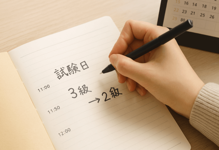 秘書検定2級3級併願のため、スケジュール帳に試験日と3級と2級の受験時間を書いている状況の画像